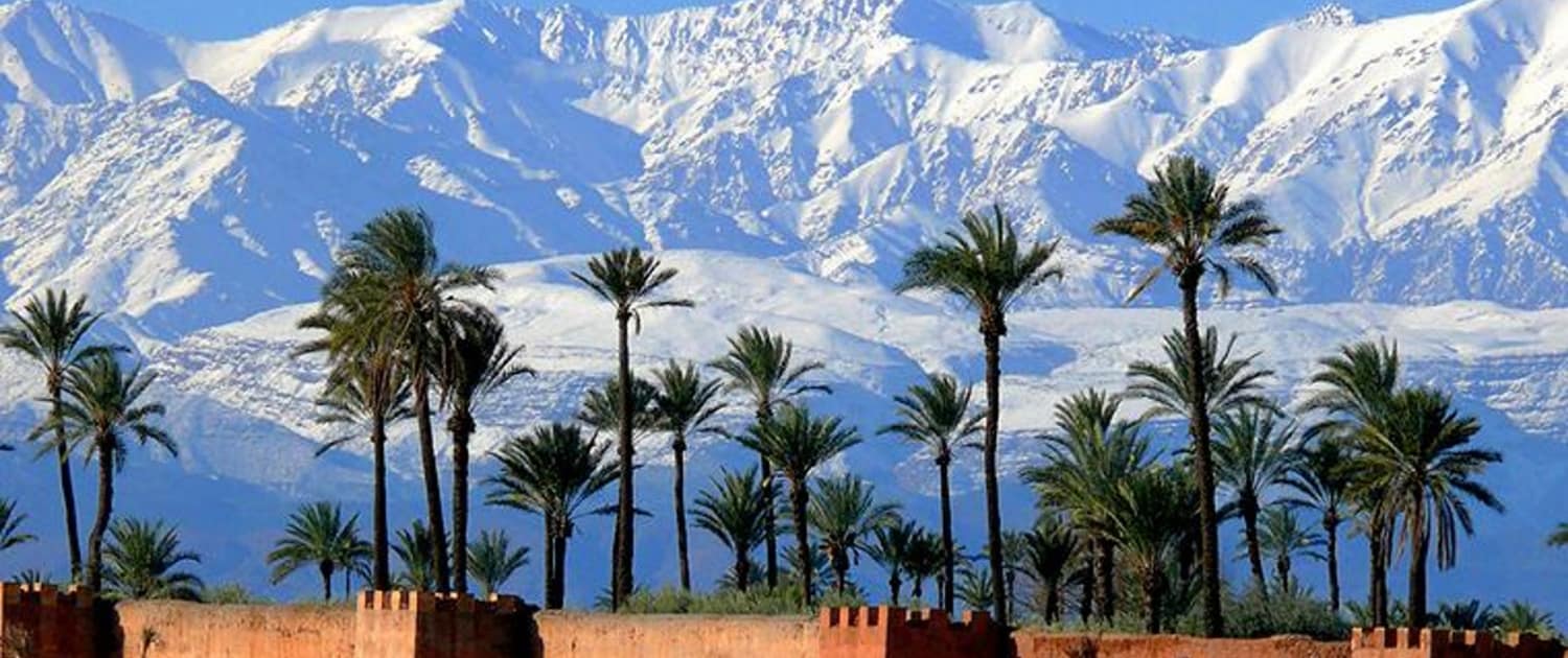 Ørkenbyen Marrakech og bjerglandskaber i baggrunden