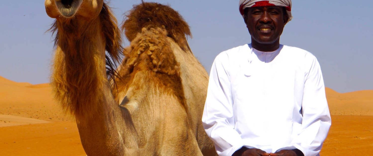 Kamel og lokal guide i ørken